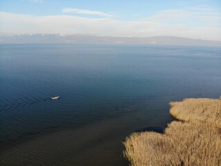 Iznik lake and a boat are moving through the reeds