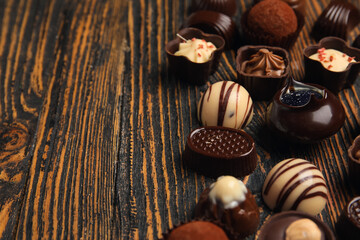 Chocolate candies on wooden background, closeup