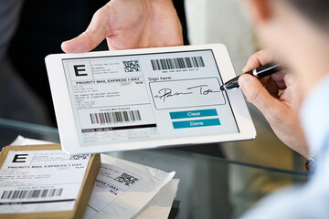 Man signing delivery receipt on digital tablet