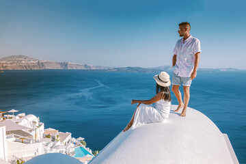 Santorini Greece, a young couple on luxury vacation at the Island of Santorini watching the sunrise...