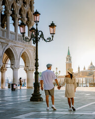 couple on a city trip in Venice, view of piazza San Marco, Doge's Palace Palazzo Ducale in Venice, Asian women and caucasian men on city trip in Venice - obrazy, fototapety, plakaty