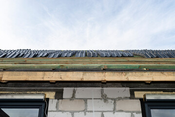 Roof ceramic tile arranged in packets on the roof on roof battens. Preparation for laying tiles on a boarded roof.