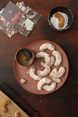 Biscuits aux noix dans une assiette rose avec une tasse de café