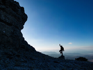 silhouette of mountaineer in peak mountains and mystical landscapes