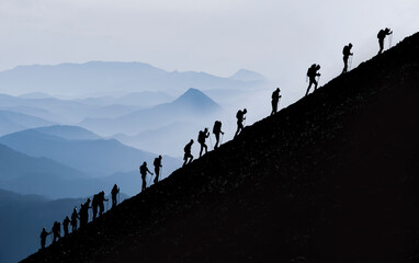 active and determined trekking of professional mountaineers to the summit and challenging sportive activities - 557884035