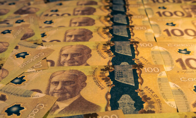 Banknotes of 100 Canadian dollars on the table.