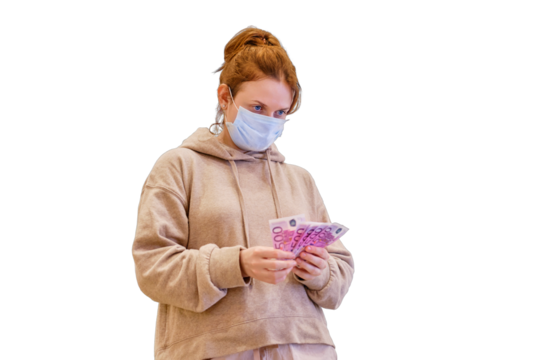 Adult woman in a medical mask stands near a store in a mall with money in euros in her hand, isolated on a white background