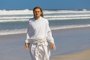 Religious image of man in white robe with beard next to sea (of Galilee)
