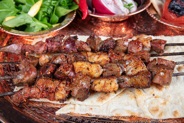 Liver kebab, one of Adana's special tastes. street flavors. Grilled beef liver on skewers, with teriyaki or soy sauce. Ciger kebab, table, liver on skewers.