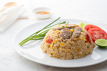 Close up Easy Pork Fried Rice with egg and tomato in white plate.asian food