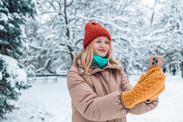 Happy blonde women taking selfie outdoors. winter, technology, friendship and people concept 