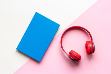 Listen to audiobook concept. Book and headphones nearby