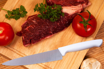 couteau viande, tomate et persil sur planche à découper