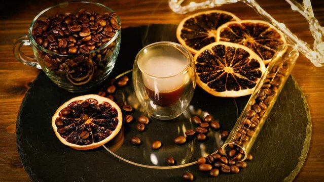 Espresso with specialty coffee beans and dried orange slices.  The coffee aroma is spreading like a fog from the espresso glass for the winter time of the year.