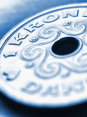 1 Danish krone coin close up. National currency of Denmark. Blue tinted vertical illustration for news about economy or finance. Banking and credit. Wages and taxes. Macro