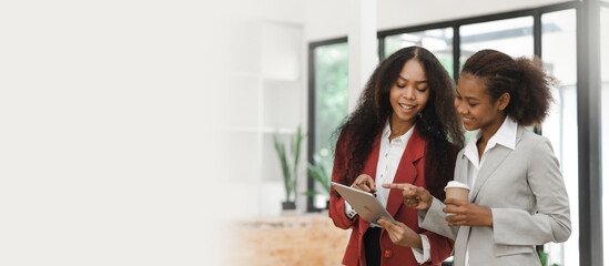 Young diverse african american female coworkers working together on start up project. Business people meeting around a boardroom table discussing creative concept