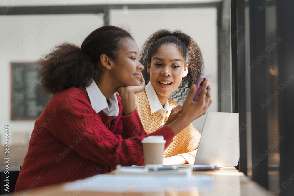 Wall mural african american girls students studying up for test or making homework together, back to school con