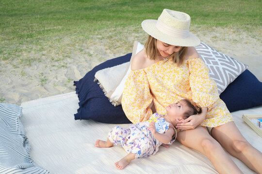 Asian mother or mom with little baby son playing while picnic in the park on a holiday, love family having fun and spending time together, Happy family concept.
