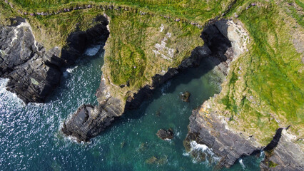 Grassy cliffs on the Atlantic Ocean coast. Landscape of Ireland from a height. Seaside rocks. Drone photo.