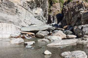 Pond with crystal clear water and small pebbles formed by Lillaz waterfall (Cascate di Lillaz) in Gran Paradiso National Park. Aosta valley, Italy