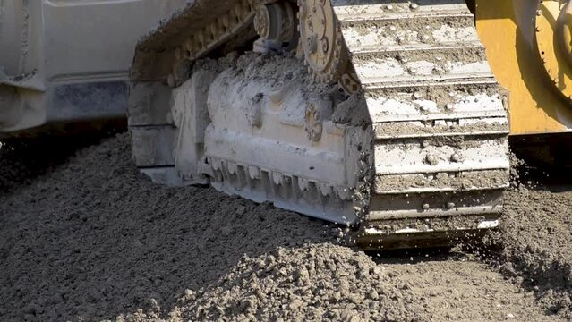 Bulldozer machine leveling construction site in close up view.