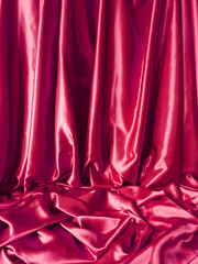 Elegant smooth red satin, silk fabric drapes. Luxurious cloth textile with liquid wave. Abstract...