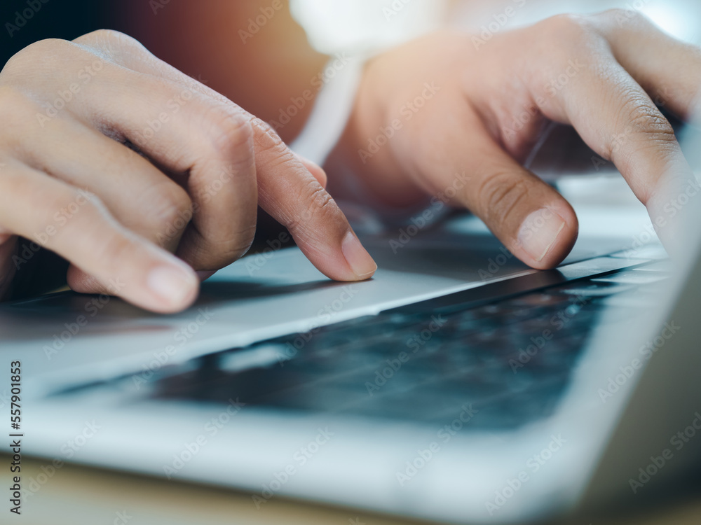 Poster close-up finger of business person in suit touch on touchpad while typing on keyboard on laptop comp