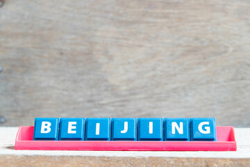 Tile alphabet letter with word beijing in red color rack on wood background
