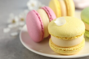 Delicious colorful macarons on grey table, closeup