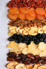 Different tasty dried fruits on paper, flat lay