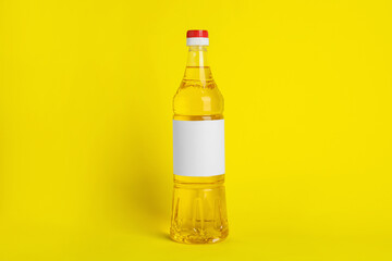 Bottle of cooking oil on yellow background
