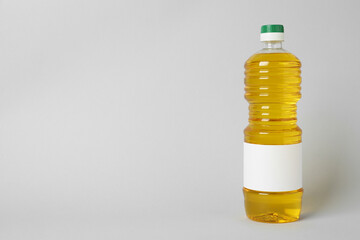 Bottle of cooking oil on light grey background. Space for text