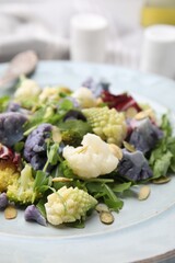 Delicious salad with cauliflower and pumpkin seeds in plate, closeup