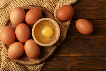 Raw chicken eggs on wooden table, flat lay. Space for text