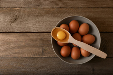 Raw chicken eggs on wooden table, top view. Space for text