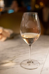 A glass of wine on the table, with blur background in the restaurant