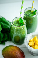 Top view of green smoothie with mango, spinach on wooden table. Healthy food. Vegetarian diet