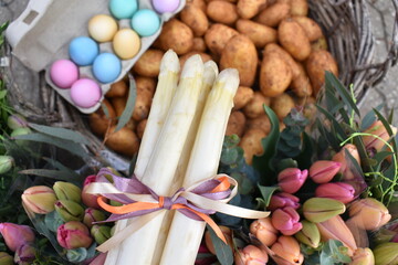 White asparagus with bow, pastel eggs, fresh potatoes and tulips for easter