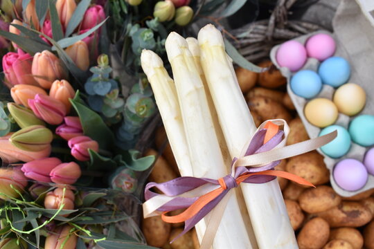 White Asparagus With Bow, Pastel Eggs, Fresh Potatoes And Tulips For Easter