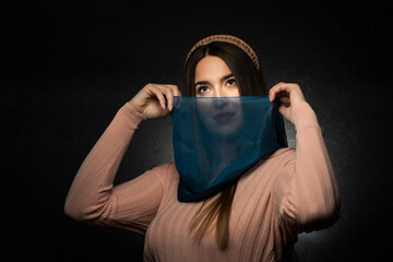 Portrait of a smiling young woman with a scarf.Studio concept.