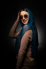 Portrait of a smiling young woman with a scarf.Studio concept.