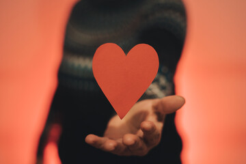 A hand receiving a red heart gravitating

