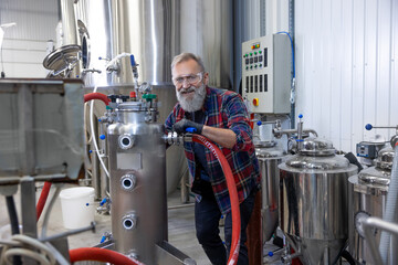 Mature man in protective eyeglasses working on a factory equipment