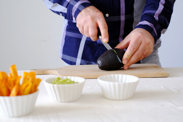 Man preparing tortilla nachos chips for a party snack