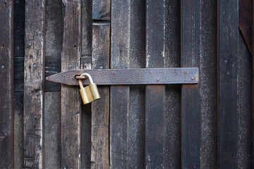 Padlock on a wooden wall. On wooden gates.