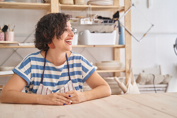 Brunette woman in blue and white striped T-shirt smiling waiting for craft class.
