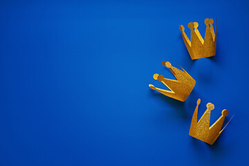 Happy Epiphany Day, Three Kings Day greeting card with three gold crowns on blue background....