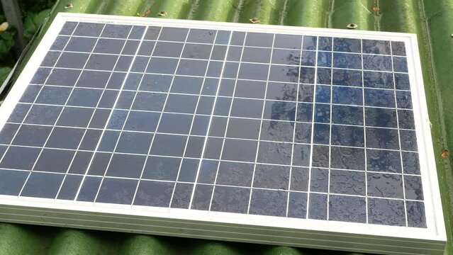 A small solar panel on the roof of a house in the rain
