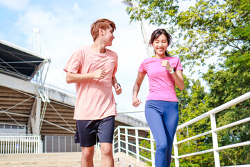 Two Asian young couples in sportswear Run outdoors early in the day. Female athletes and male...