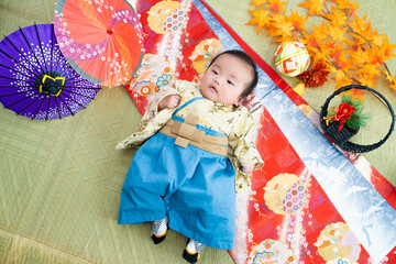 お正月に日本的で和風の袴姿で寝転ぶ生後3か月の赤ちゃん